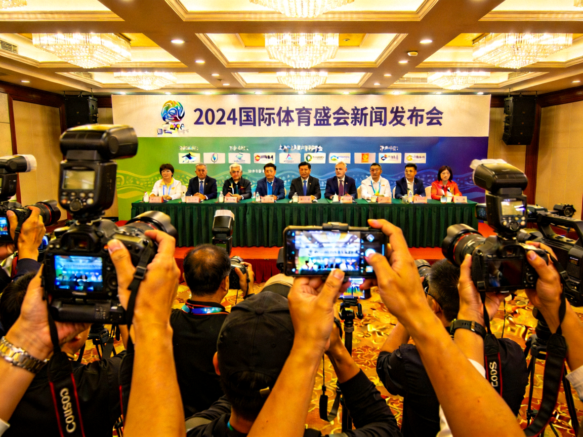 大型体育赛事新闻发布会现场，台上嘉宾云集，台下媒体记者举着相机拍摄